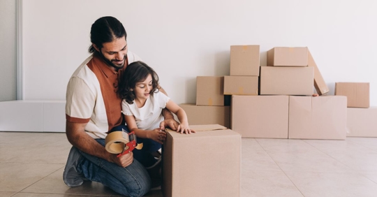 dad and child packing boxes to move