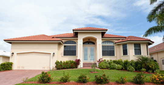 Photo of house with blue skies and green yard.