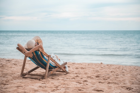 Woman relaxing on beach chair in sand