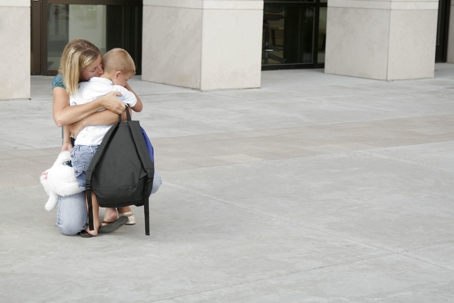 A mother hugs her small child as she drops him off at school