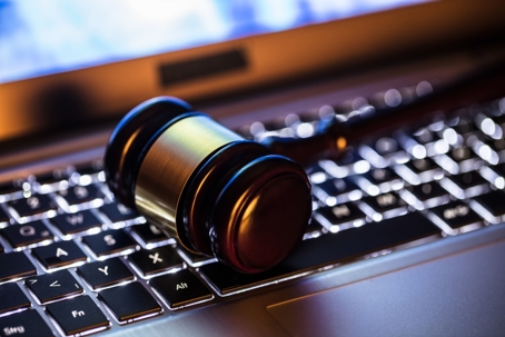 A gavel sits on top of a backlit laptop keyboard
