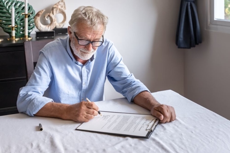 Older man signing papers