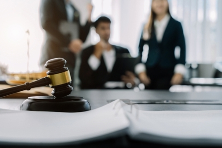 hammer of justice with scales and auction hammer, the team meeting at the law firm behind the concept of in office law.