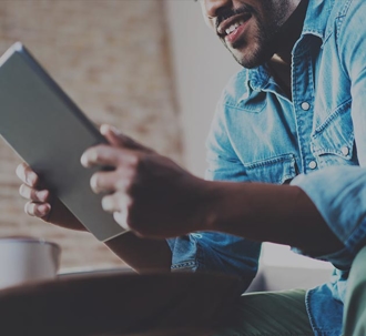 smiling man looking at a tablet