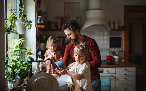 father doing dishes with two children